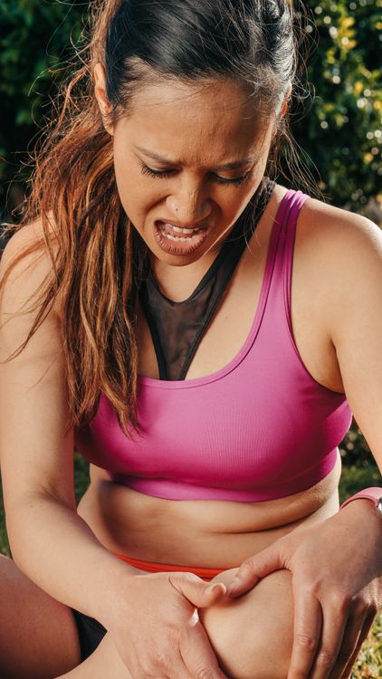 Close-up of a woman holding her knee in discomfort