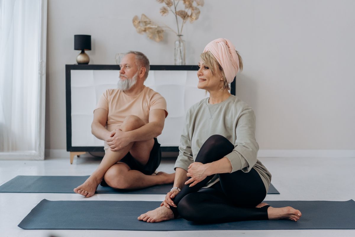 Older couple exercising gently together at home to stay strong and mobile