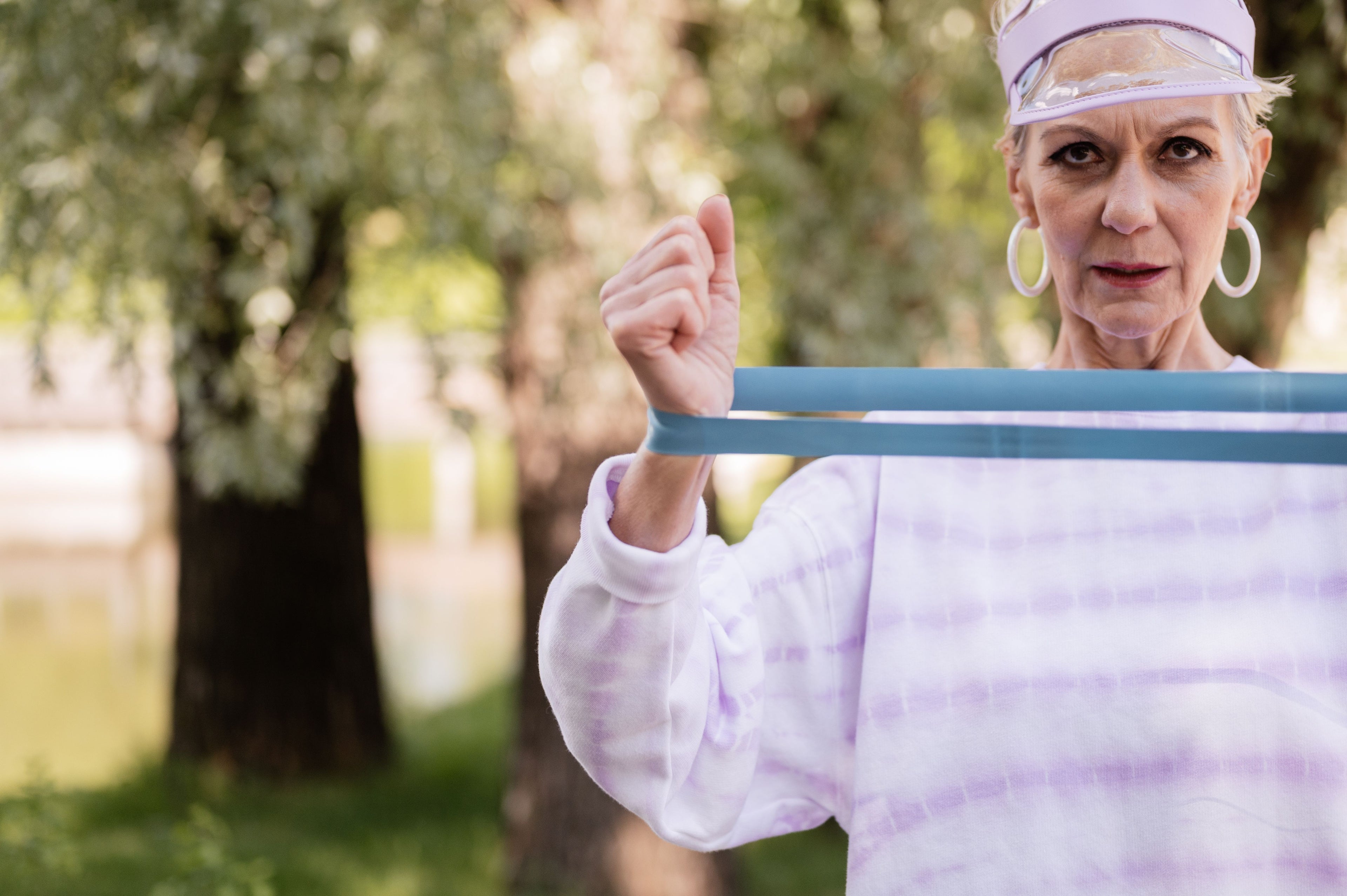 Senior woman working out with a resistance band outdoors